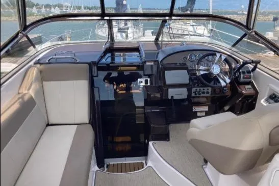Slide: The Image of Interior of 2013 Regal 30 Express boat with steering wheel and seating area. - 18