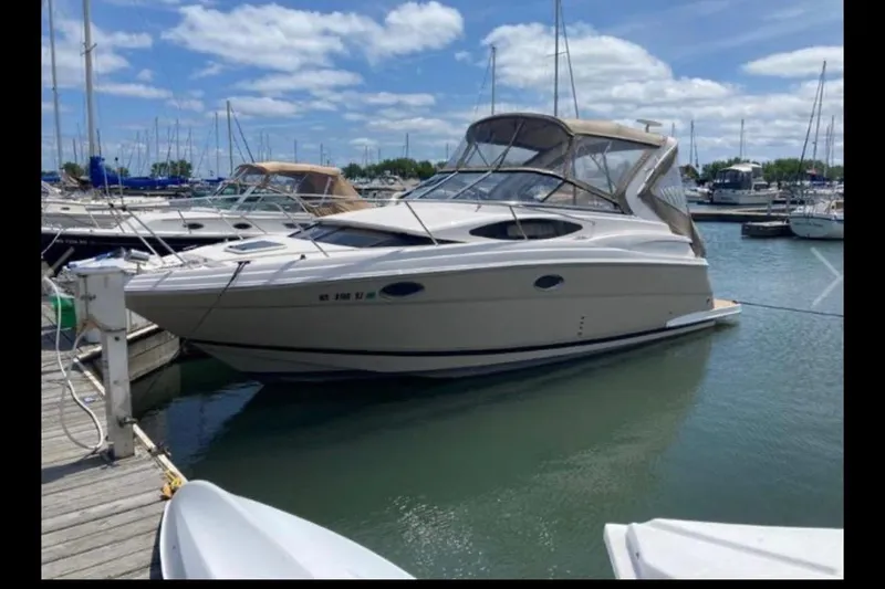 Slide: The Image of 2013 Regal 30 Express boat docked in a marina under a partly cloudy sky. - 2