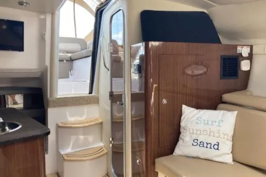 Slide: The Image of Interior of 2013 Regal 30 Express boat with cozy seating and nautical decor. - 21