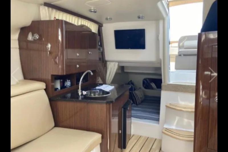 Slide: The Image of Interior of 2013 Regal 30 Express boat with kitchenette and seating area. - 22