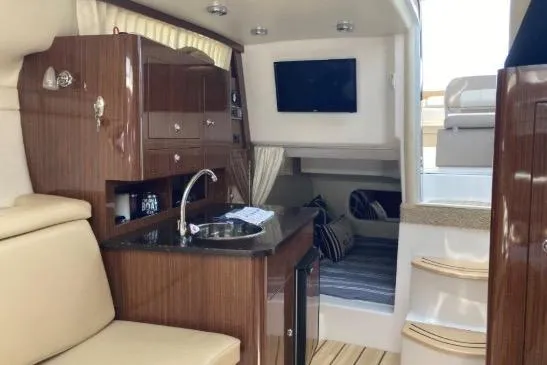 Slide: The Image of Luxurious interior of 2013 Regal 30 Express boat with kitchenette and seating area. - 27