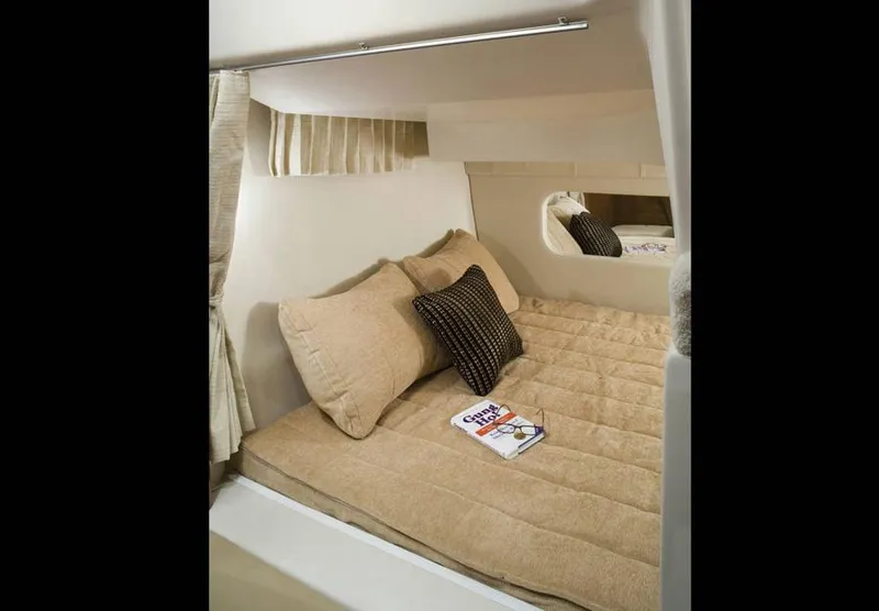 Slide: The Image of Manufacturer Provided Image: Cozy cabin bed in 2013 Regal 30 Express boat with beige bedding and pillows. - 32