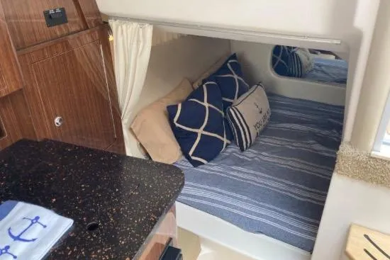 Slide: The Image of Cozy cabin interior of 2013 Regal 30 Express boat with nautical-themed bedding. - 35