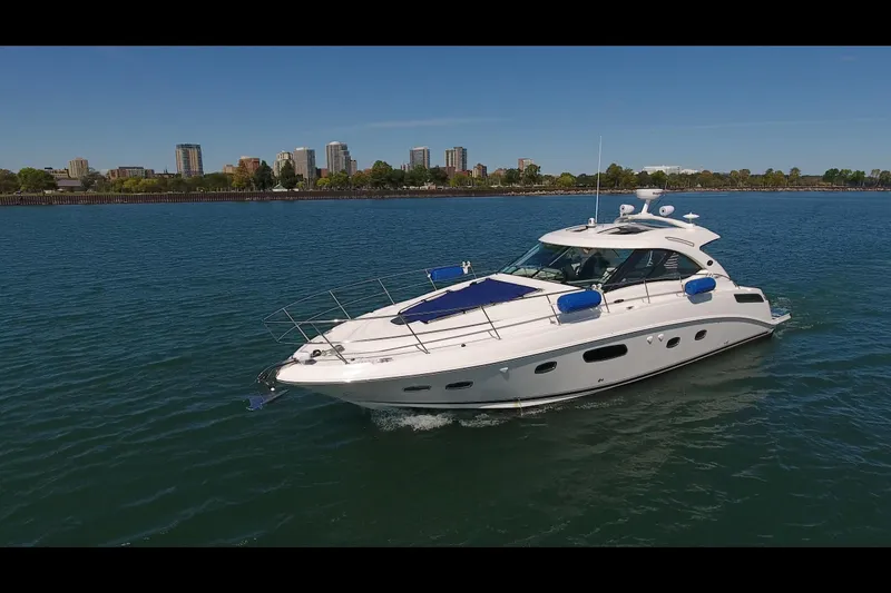 Slide: The Image of 2011 Sea Ray 470 Sundancer yacht cruising on a sunny day near city skyline. - 12