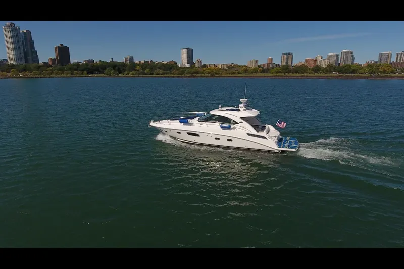 Slide: The Image of 2011 Sea Ray 470 Sundancer cruising on a city waterfront with skyline in background. - 14