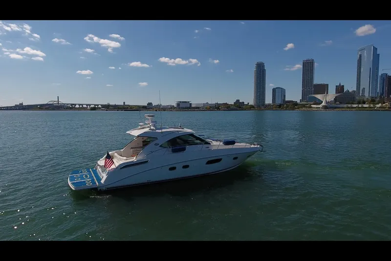 Slide: The Image of 2011 Sea Ray 470 Sundancer yacht cruising near city skyline on a sunny day. - 17