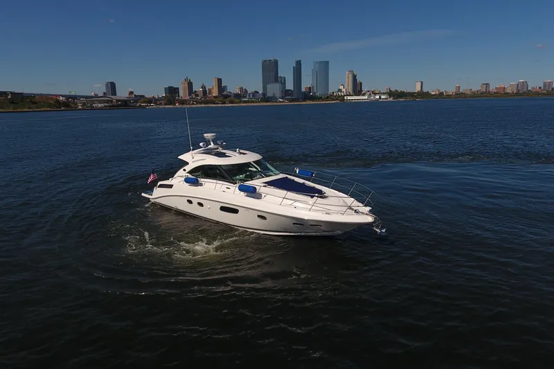Slide: The Image of 2011 Sea Ray 470 Sundancer yacht cruising near city skyline on a sunny day. - 2
