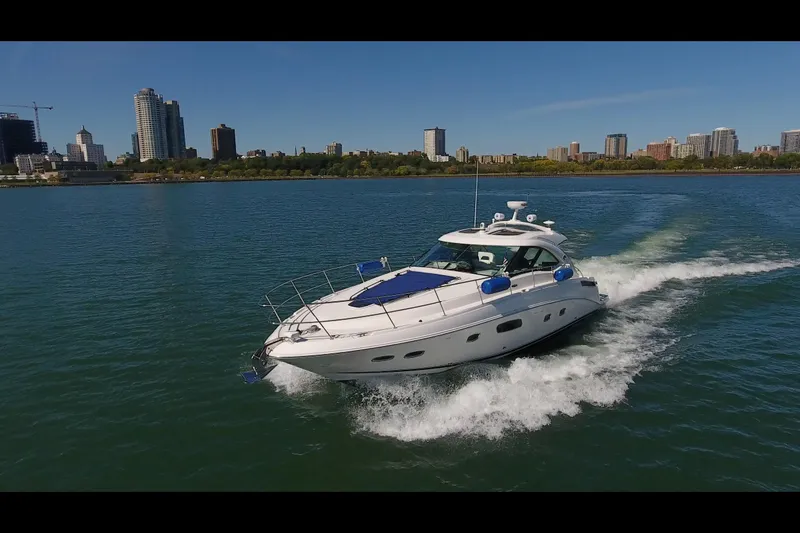 Slide: The Image of 2011 Sea Ray 470 Sundancer cruising on a city waterfront with skyline backdrop. - 21