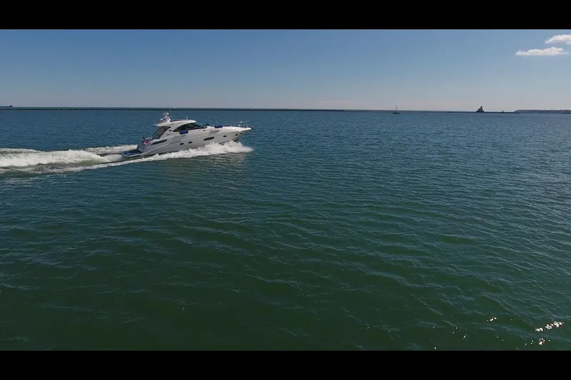 Slide: The Image of 2011 Sea Ray 470 Sundancer cruising on open water under clear blue skies. - 24