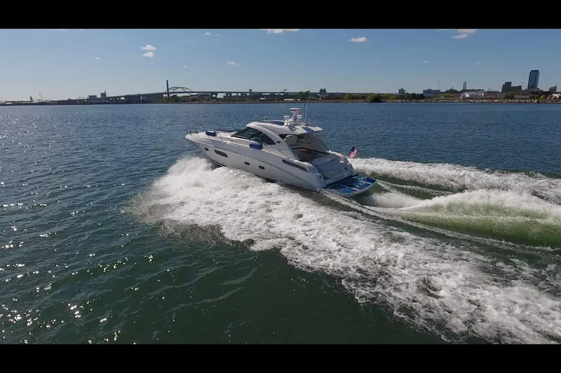 Slide: The Image of 2011 Sea Ray 470 Sundancer cruising on open water, creating waves. - 27