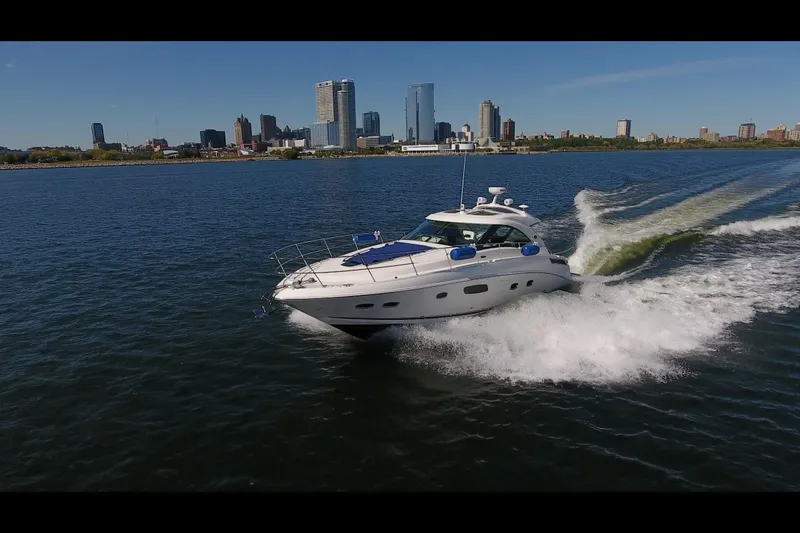 Slide: The Image of 2011 Sea Ray 470 Sundancer cruising on water with city skyline in background. - 30