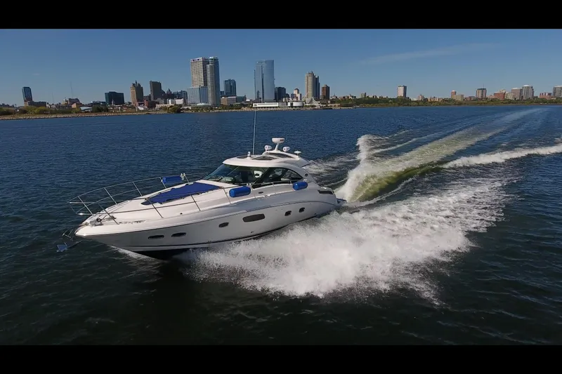 Slide: The Image of 2011 Sea Ray 470 Sundancer cruising on water with city skyline in background. - 31