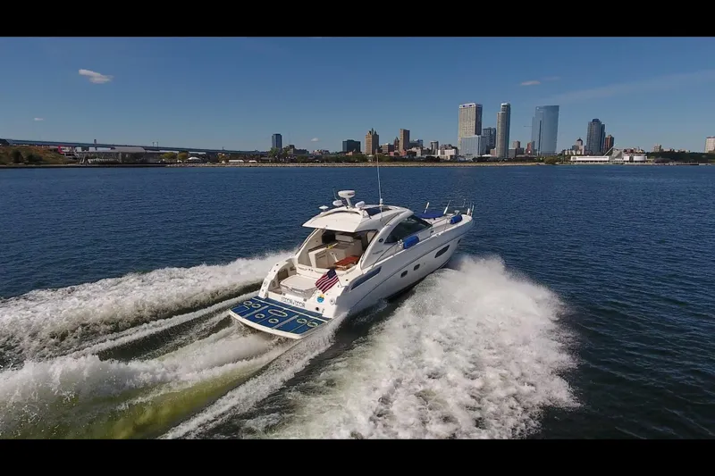Slide: The Image of 2011 Sea Ray 470 Sundancer cruising on water with city skyline in background. - 32