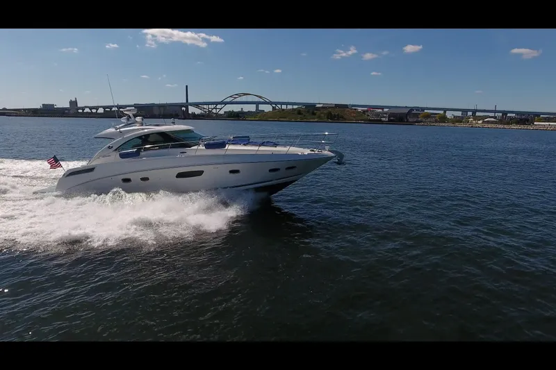 Slide: The Image of 2011 Sea Ray 470 Sundancer cruising on open water under a clear blue sky. - 33