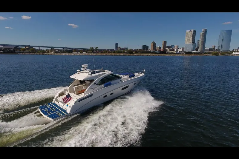 Slide: The Image of 2011 Sea Ray 470 Sundancer cruising on water with city skyline in background. - 34