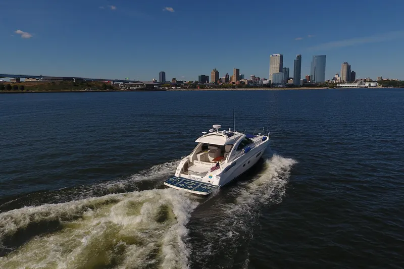 Slide: The Image of 2011 Sea Ray 470 Sundancer cruising on water with city skyline in background. - 7