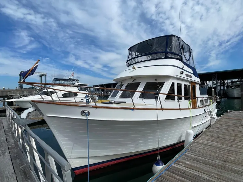 The Image of 1983 Ocean Alexander TRI Cabin yacht docked at marina under blue sky. - 0