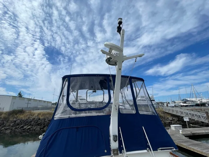 Slide: The Image of 1983 Ocean Alexander TRI Cabin boat docked under a partly cloudy sky. - 14