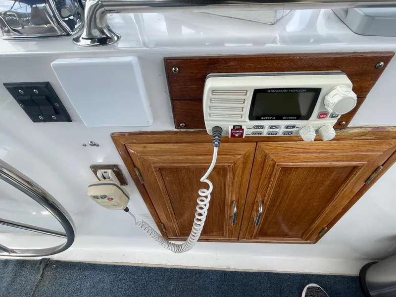 Slide: The Image of 1983 Ocean Alexander TRI Cabin boat control panel with radio and wooden cabinet. - 22