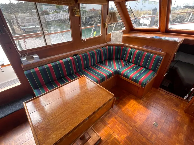 Slide: The Image of 1983 Ocean Alexander TRI Cabin interior with striped seating and wooden table. - 29