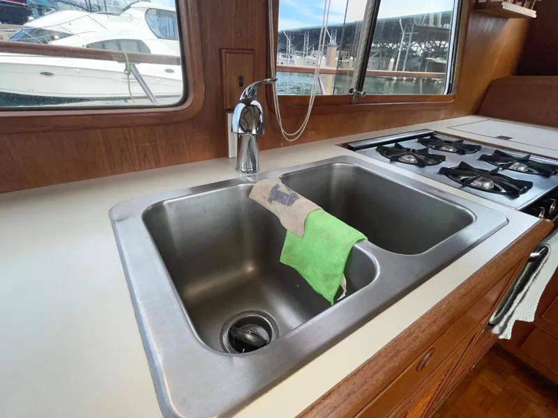 Slide: The Image of 1983 Ocean Alexander TRI Cabin kitchen sink and stove with marina view. - 34