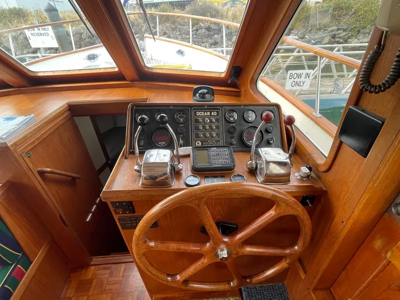 Slide: The Image of 1983 Ocean Alexander 40 Double Cabin helm with wooden wheel and navigation controls. - 38