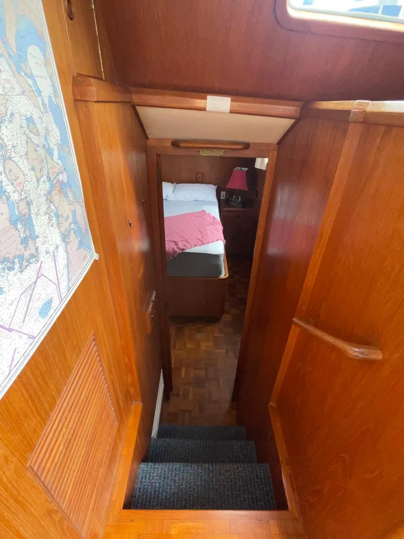 Slide: The Image of 1983 Ocean Alexander TRI Cabin interior with wooden stairs and cozy bedroom. - 51