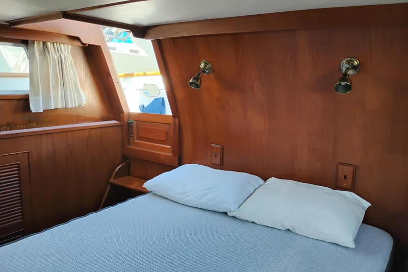 Slide: The Image of 1983 Ocean Alexander 40 Double Cabin interior with wood paneling and cozy bed. - 54