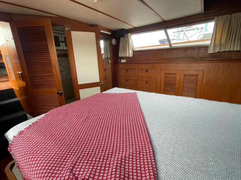 Slide: The Image of 1983 Ocean Alexander TRI Cabin bedroom with wooden cabinetry and large bed. - 57