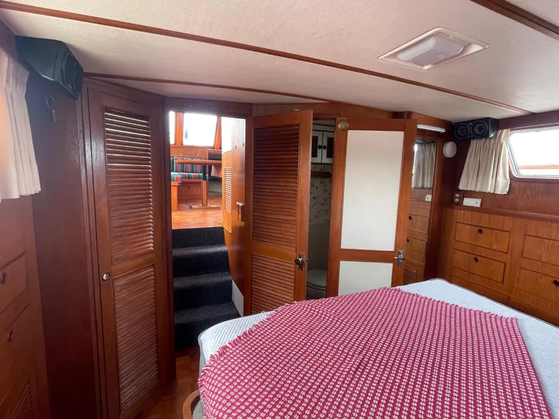 Slide: The Image of 1983 Ocean Alexander TRI Cabin interior with wooden finishes and cozy bedroom. - 58