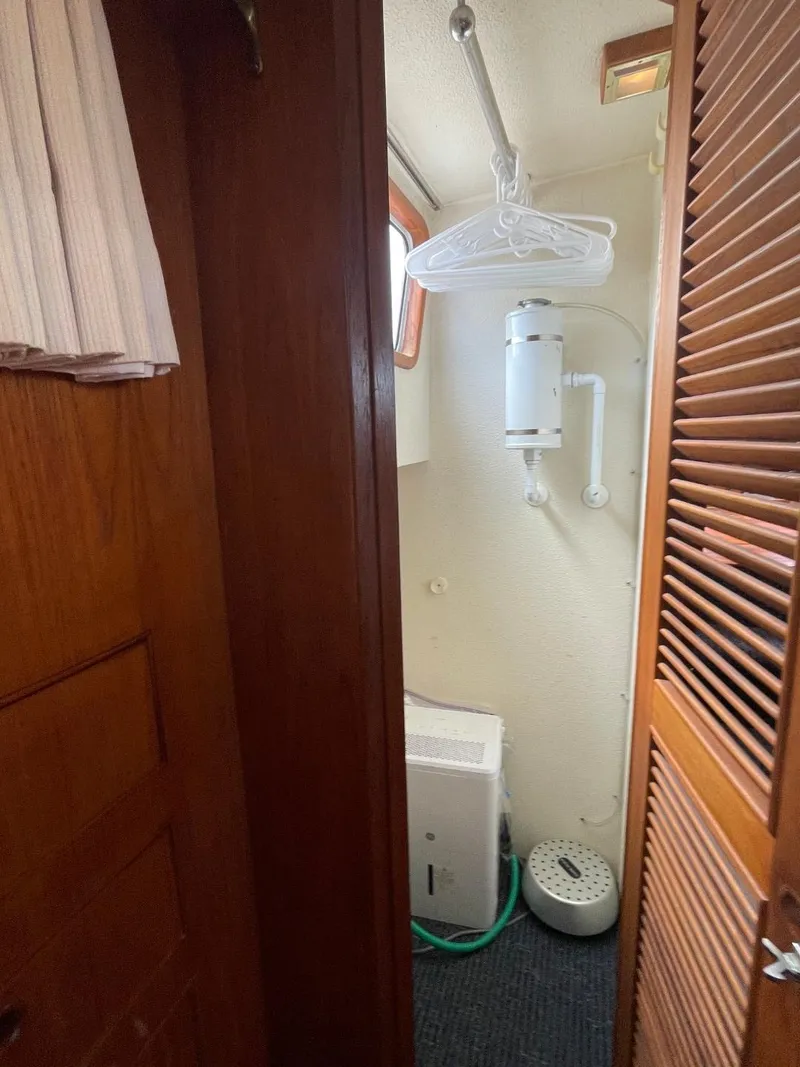 Slide: The Image of 1983 Ocean Alexander TRI Cabin interior closet with wooden doors and hanging space. - 59