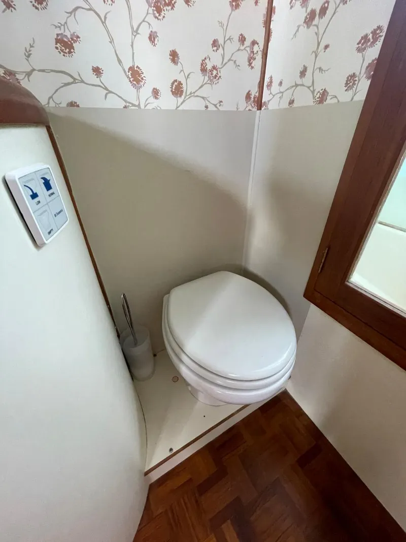 Slide: The Image of 1983 Ocean Alexander TRI Cabin bathroom with floral wallpaper and wooden flooring. - 61