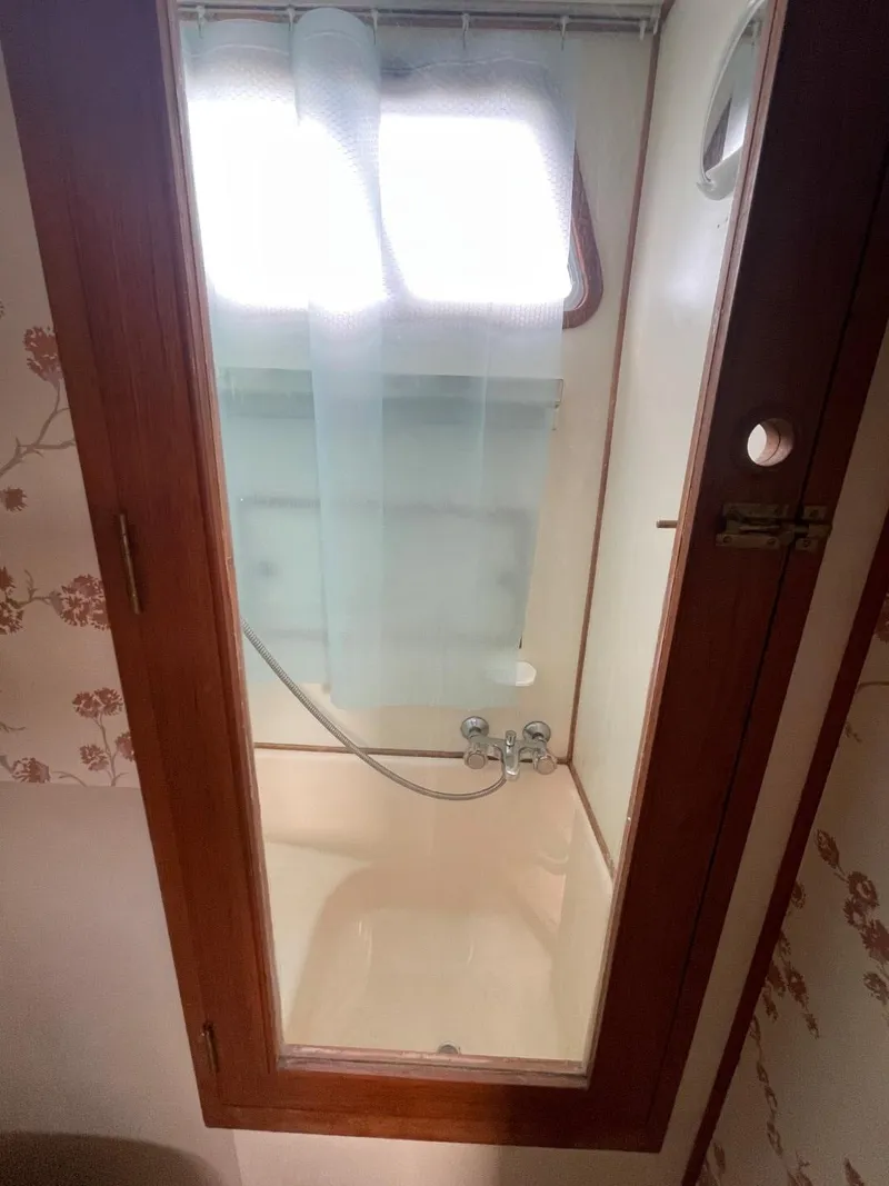 Slide: The Image of 1983 Ocean Alexander TRI Cabin shower with wooden door and floral wallpaper. - 62
