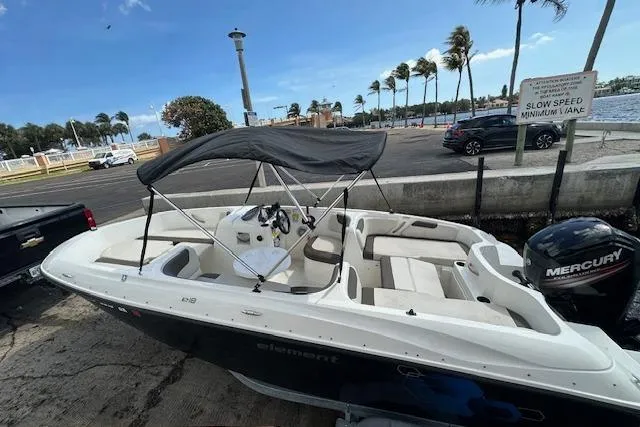 Slide: The Image of 2018 Bayliner Element E18 boat docked with canopy and Mercury outboard motor. - 5