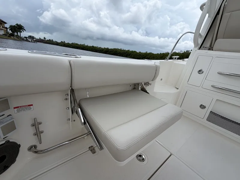 Slide: The Image of The 2027 Boston Whaler 325 Conquest features a sleek, white outdoor seat with a view of the water. - 9