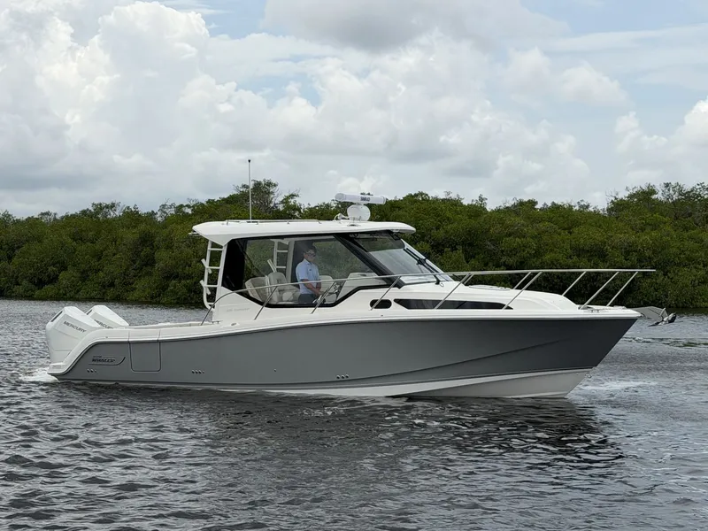 Slide: The Image of A 2027 Boston Whaler 325 Conquest cruising on calm water. The sky is cloudy. - 34