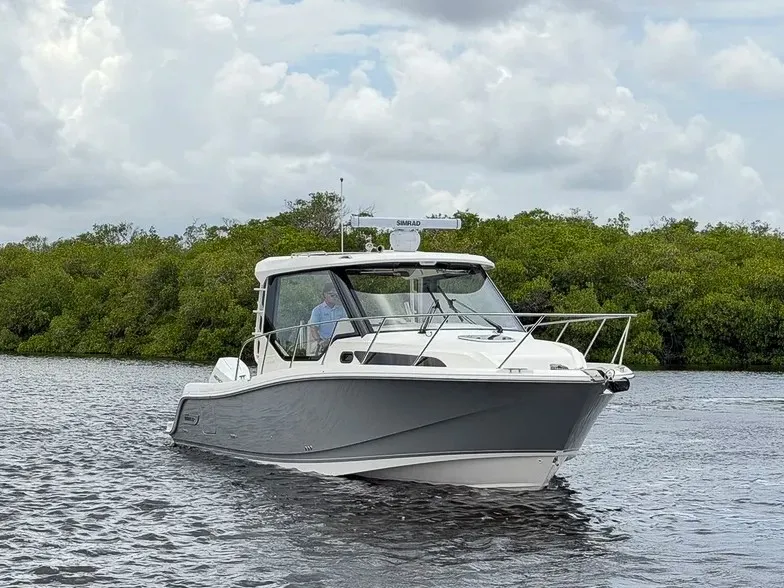 Slide: The Image of A 2027 Boston Whaler 325 Conquest cruising on calm waters under a cloudy sky. - 30