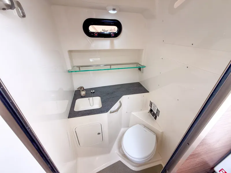 Slide: The Image of The image shows a modern boat bathroom with a toilet, sink, and small window. - 27