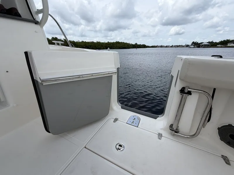 Slide: The Image of The 2027 Boston Whaler 325 Conquest features an open door to the swim platform overlooking the water. - 11