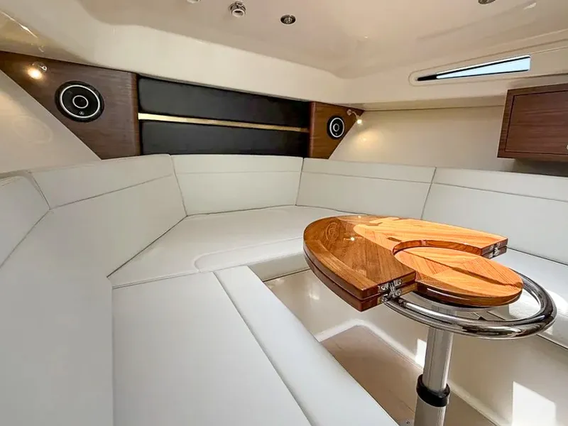 Slide: The Image of The cabin of the 2027 Boston Whaler 325 Conquest features elegant white upholstery and a wooden table. - 22