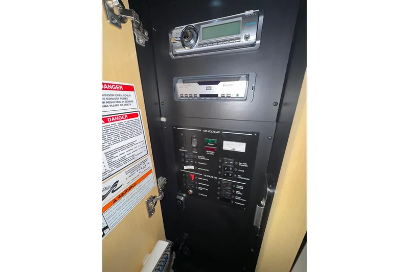 Slide: The Image of Electrical control panel inside 2010 Sea Ray Sundancer 280 boat, featuring stereo and warning labels. - 20