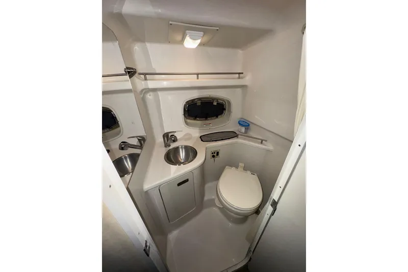 Slide: The Image of 2010 Sea Ray Sundancer 280 bathroom with sink, toilet, and porthole window. - 22