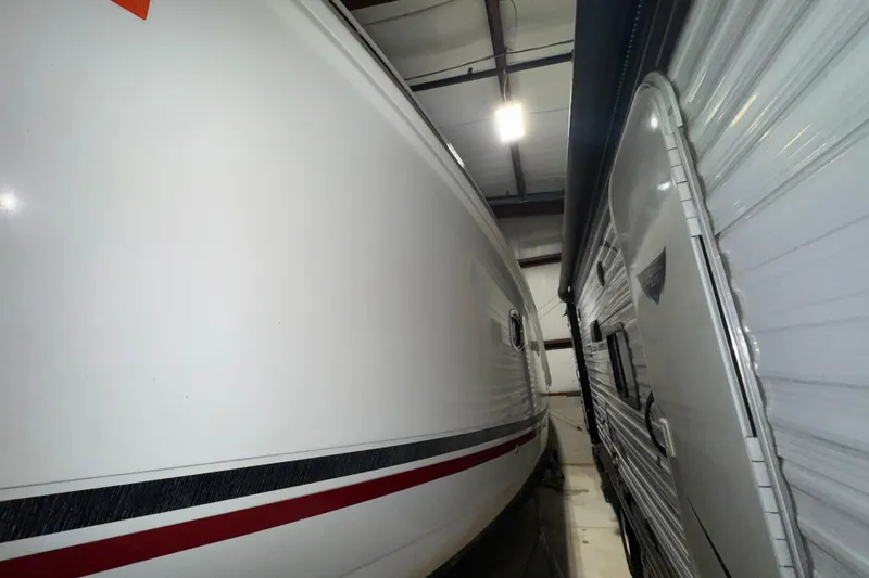 Slide: The Image of 2010 Sea Ray Sundancer 280 stored indoors beside another vehicle. - 4