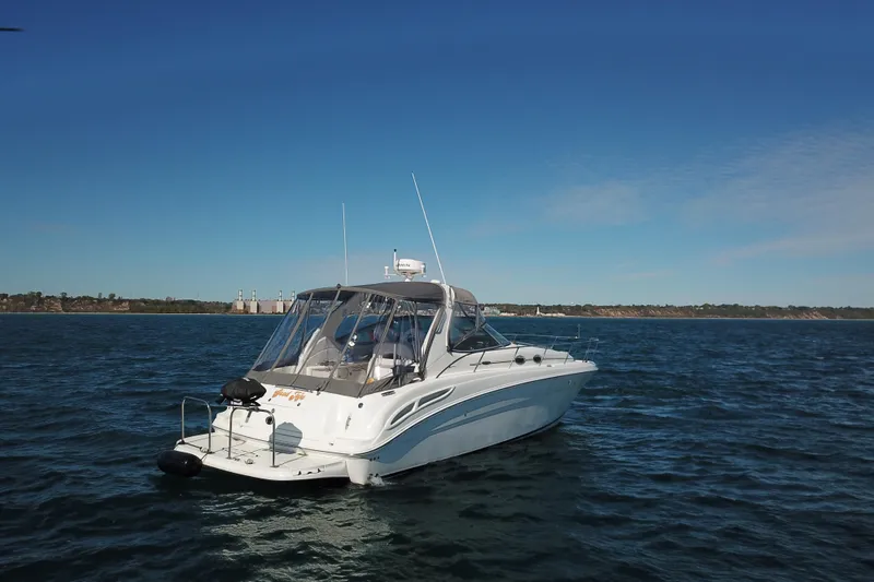 Slide: The Image of 2005 Sea Ray 360 Sundancer yacht cruising on open water under clear blue skies. - 10