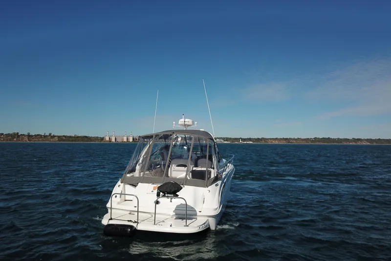 Slide: The Image of 2005 Sea Ray 360 Sundancer cruising on open water under clear blue skies. - 11