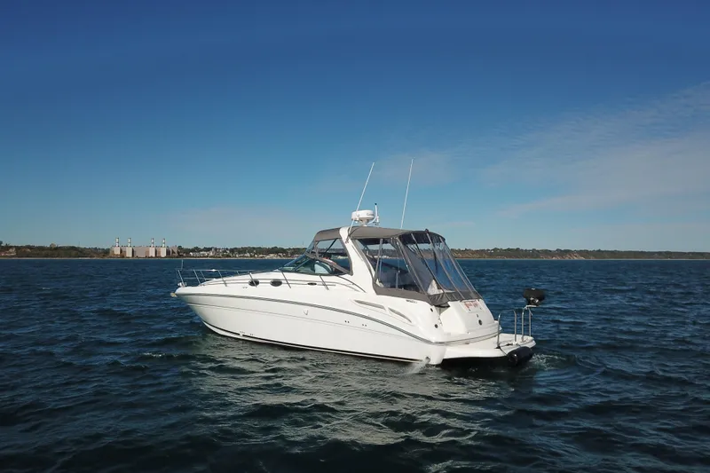 Slide: The Image of 2005 Sea Ray 360 Sundancer yacht on open water under clear blue sky. - 12