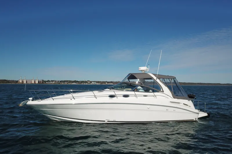 Slide: The Image of 2005 Sea Ray 360 Sundancer yacht cruising on open water under clear blue skies. - 14