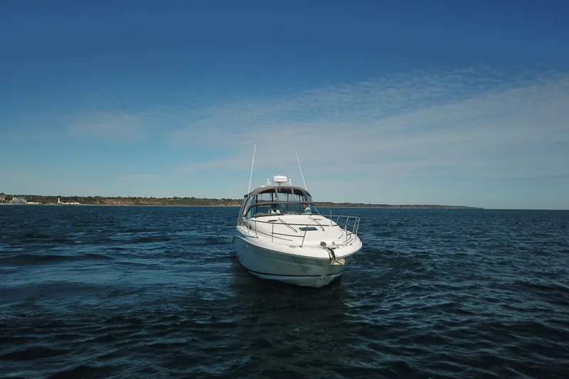 Slide: The Image of 2005 Sea Ray 360 Sundancer yacht cruising on open water under clear blue sky. - 16