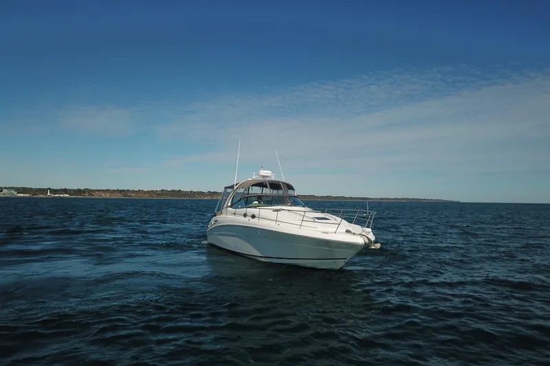Slide: The Image of 2005 Sea Ray 360 Sundancer yacht cruising on open water under clear blue skies. - 17