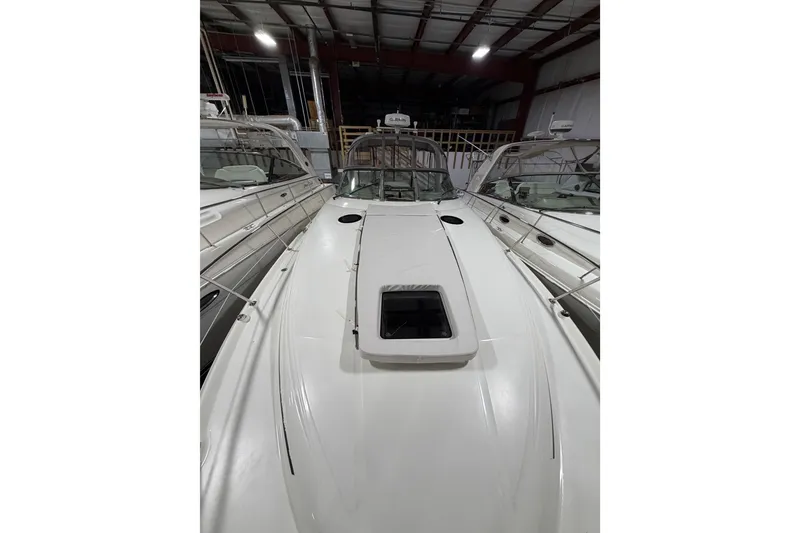 Slide: The Image of 2005 Sea Ray 360 Sundancer yacht in indoor storage, showcasing sleek design and spacious deck. - 23